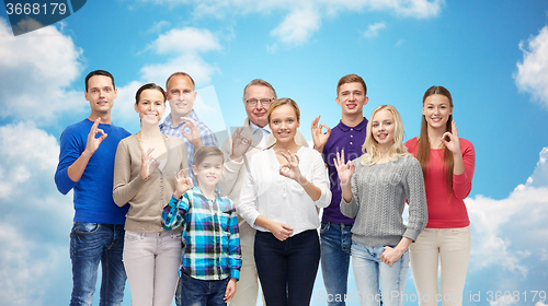 Image of group of smiling people showing ok hand sign