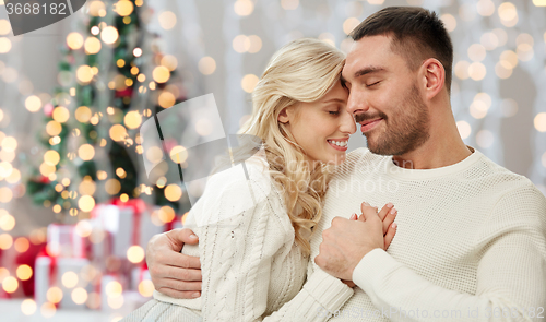 Image of happy couple over christmas tree lights background