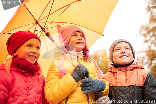 Image of happy children with umbrella in autumn park