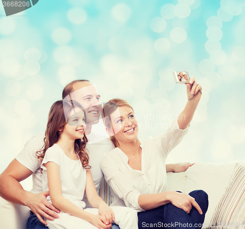 Image of happy family with camera at home