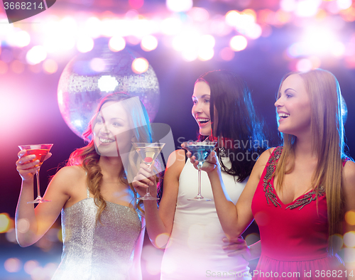 Image of smiling women with cocktails at night club