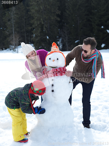 Image of happy family making snowman