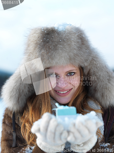 Image of portrait of  girl with gift at winter scene and snow in backgron