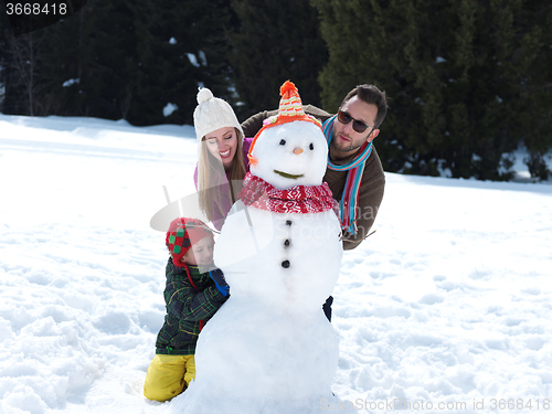 Image of happy family making snowman