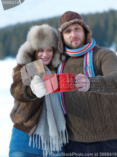 Image of happy young couple drink warm tea at winter