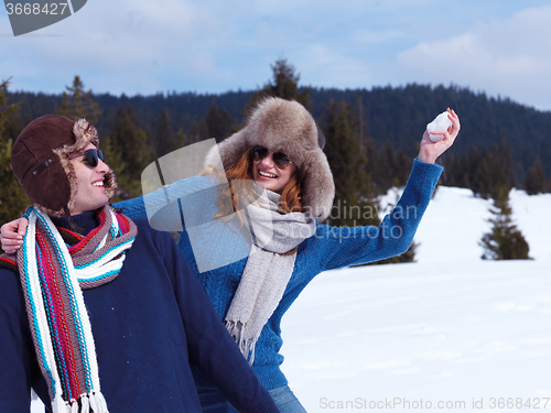 Image of happy young couple having fun on fresh show on winter vacation