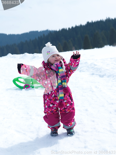 Image of little baby girl have fun on fresh snow