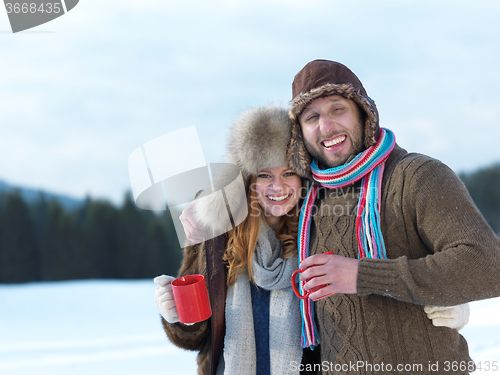 Image of happy young couple drink warm tea at winter