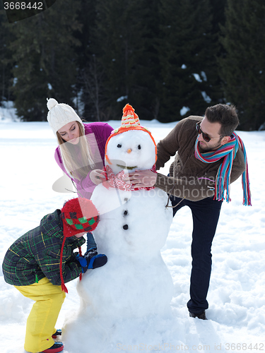 Image of happy family making snowman