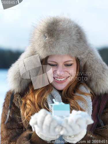 Image of portrait of  girl with gift at winter scene and snow in backgron