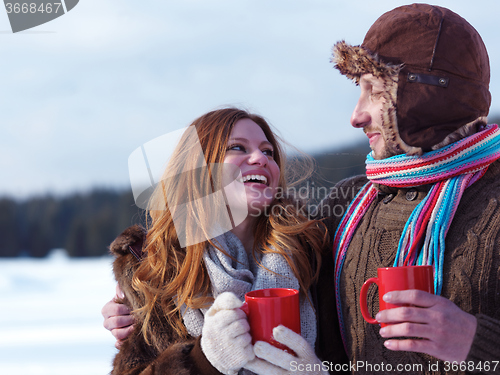 Image of happy young couple drink warm tea at winter