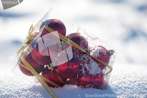 Image of christmas balls in box on fresh  snow