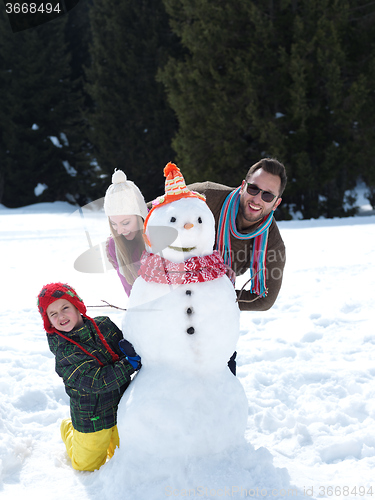 Image of happy family making snowman