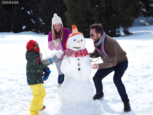 Image of happy family making snowman