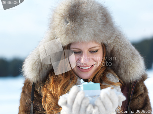 Image of portrait of  girl with gift at winter scene and snow in backgron