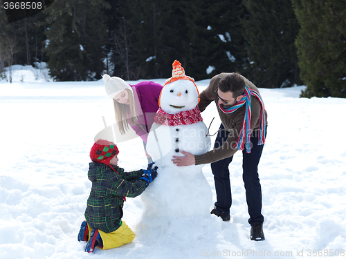 Image of happy family making snowman