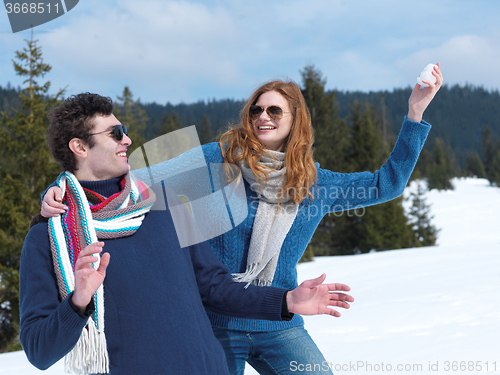 Image of happy young couple having fun on fresh show on winter vacation