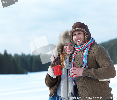 Image of happy young couple drink warm tea at winter