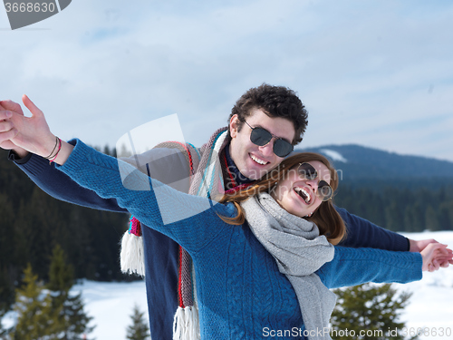 Image of happy young couple having fun on fresh show on winter vacation