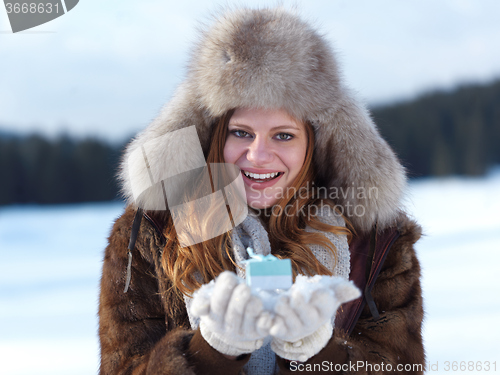 Image of portrait of  girl with gift at winter scene and snow in backgron