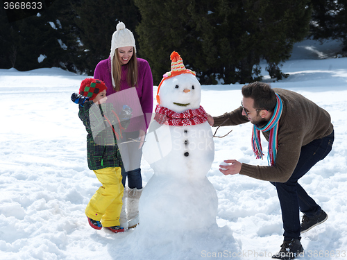 Image of happy family making snowman