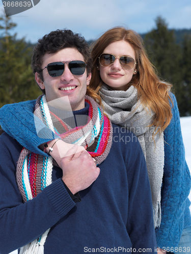 Image of happy young couple having fun on fresh show on winter vacation