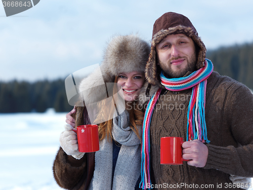 Image of happy young couple drink warm tea at winter