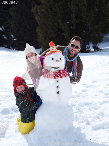 Image of happy family making snowman