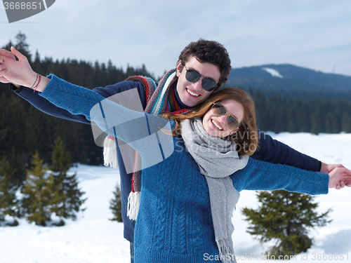 Image of happy young couple having fun on fresh show on winter vacation