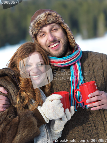 Image of happy young couple drink warm tea at winter