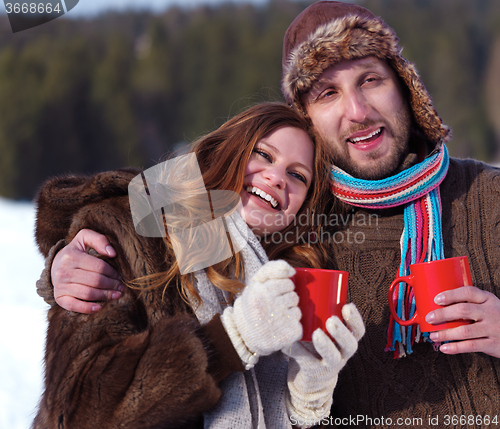 Image of happy young couple drink warm tea at winter