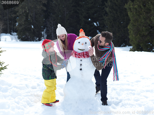 Image of happy family making snowman