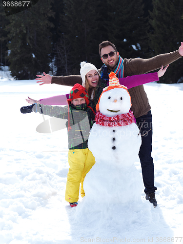 Image of happy family making snowman