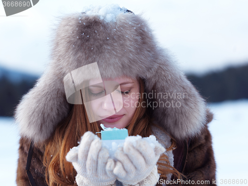 Image of portrait of  girl with gift at winter scene and snow in backgron