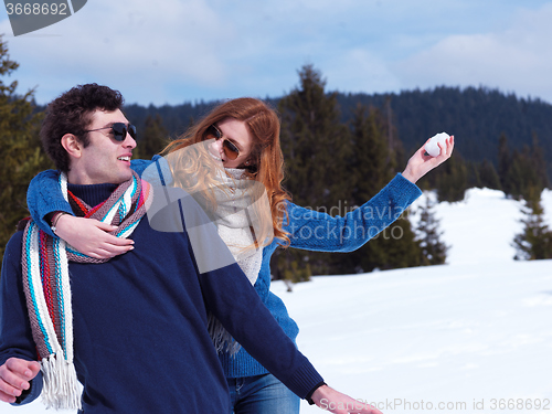 Image of happy young couple having fun on fresh show on winter vacation