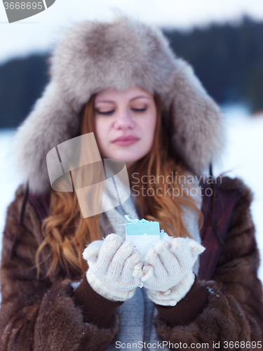 Image of portrait of  girl with gift at winter scene and snow in backgron