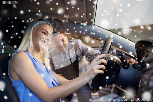 Image of happy woman with car dealer in auto show or salon