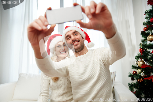 Image of couple taking selfie with smartphone at christmas