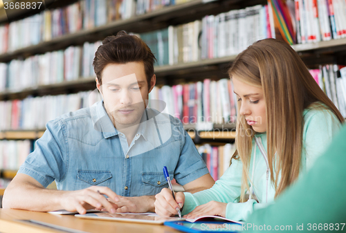 Image of students writing to notebooks in library