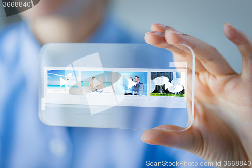 Image of close up of woman with transparent smartphone