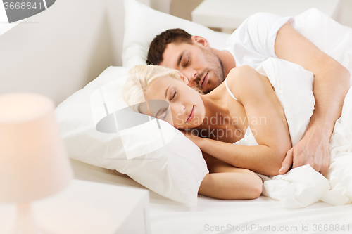 Image of happy couple sleeping in bed at home