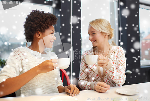 Image of happy young women drinking tea or coffee at cafe