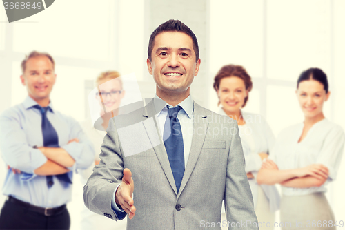 Image of happy smiling businessman in suit shaking hand