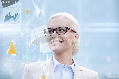 Image of young smiling businesswoman in eyeglasses outdoors