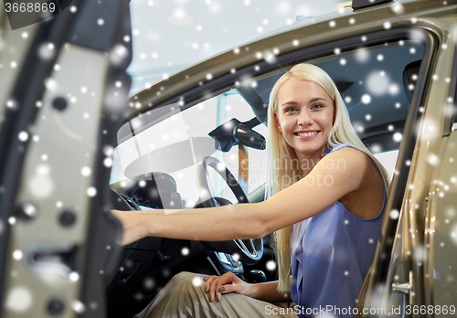 Image of happy woman inside car in auto show or salon