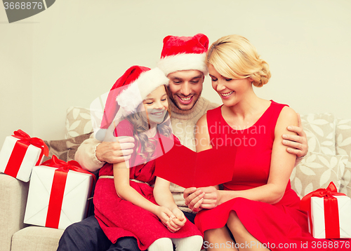 Image of smiling family reading postcard