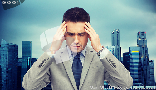 Image of businessman in suit having head ache