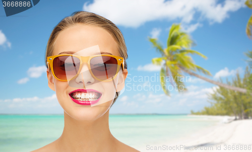 Image of happy young woman in sunglasses with pink lipstick