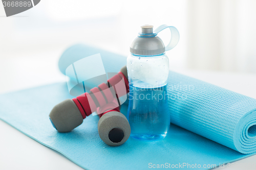 Image of close up of bottle, dumbbells and sports mat