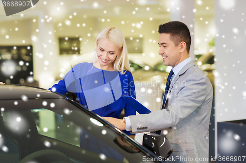 Image of happy woman with car dealer in auto show or salon